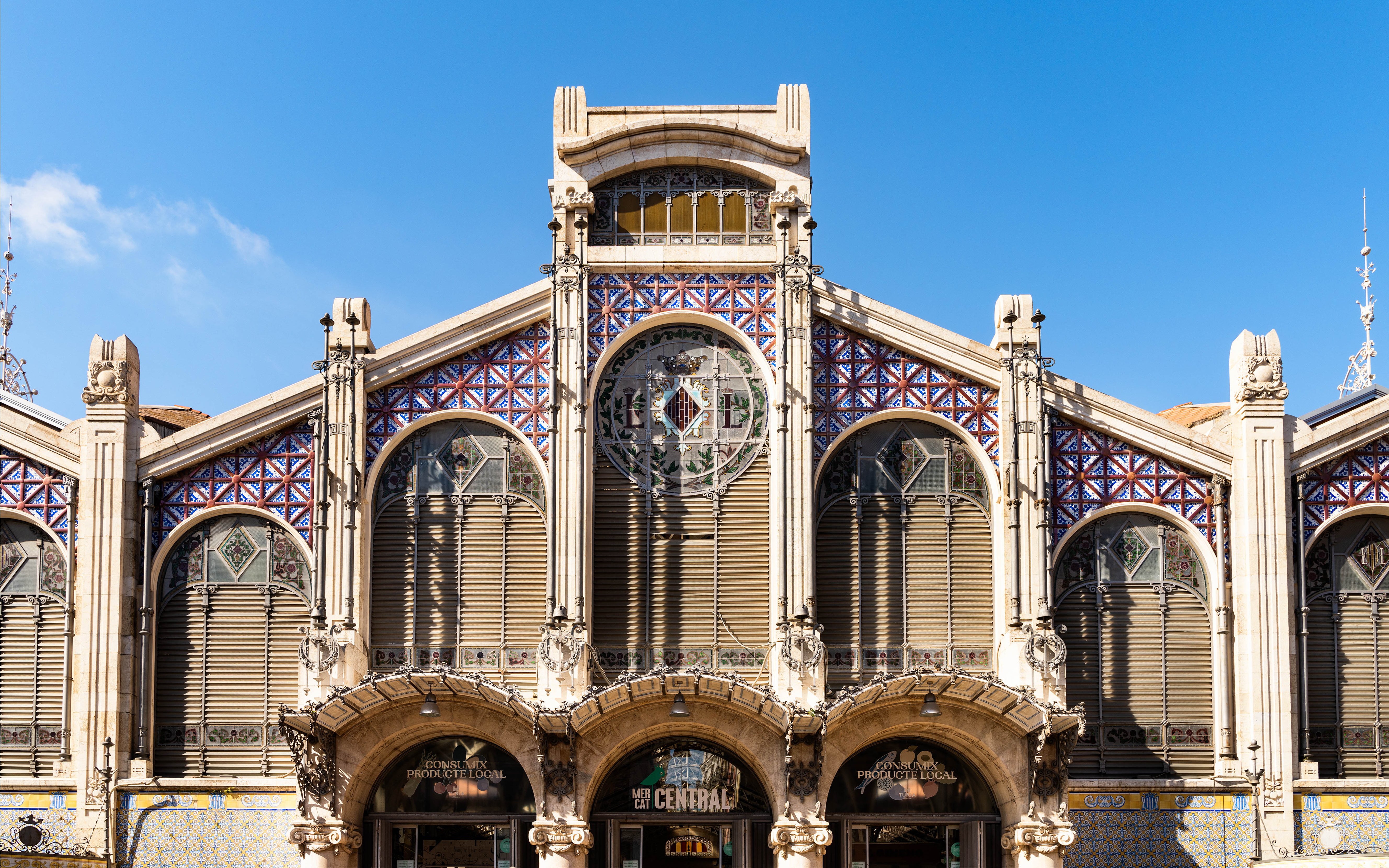 Facade of Mercado Central in Valencia with decorative tiles and arched windows.