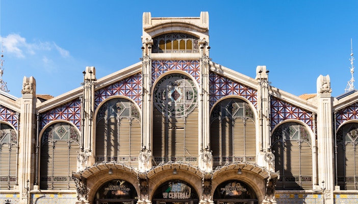 Facade of Mercado Central in Valencia with decorative tiles and arched windows.