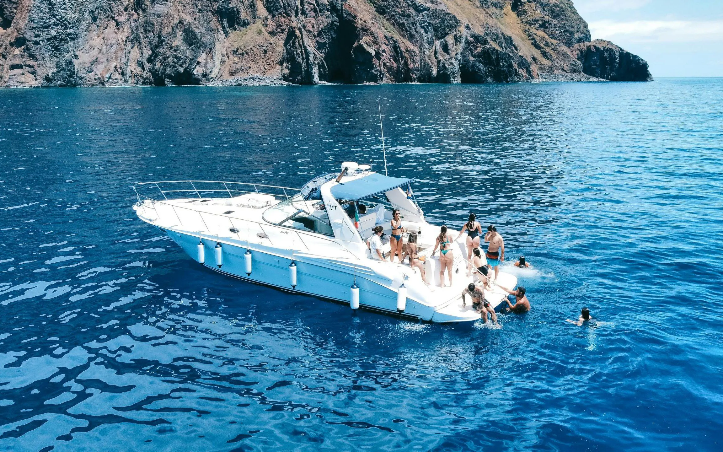 Boat tour near Calheta with people swimming and enjoying dolphin and whale watching.