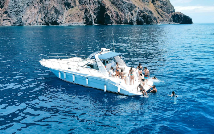 Boat tour near Calheta with people swimming and enjoying dolphin and whale watching.