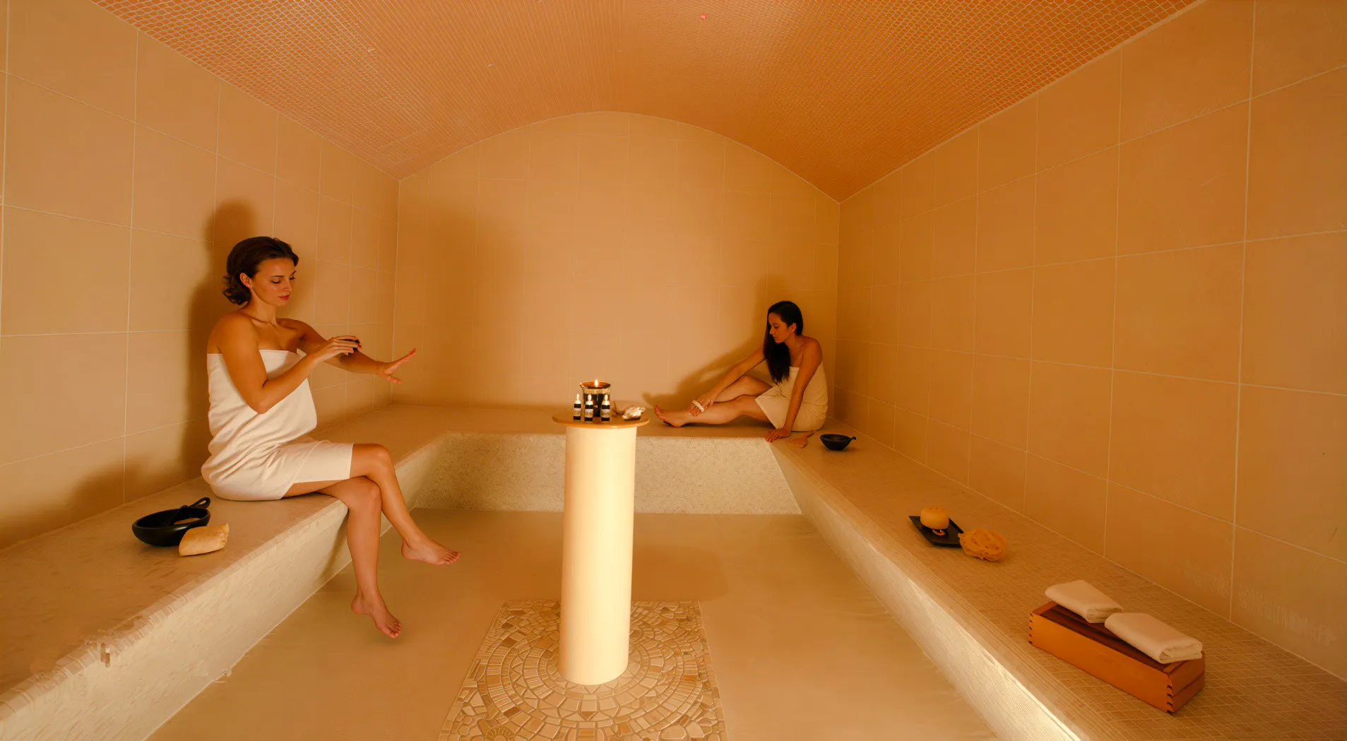 Women relaxing in a Moroccan hammam in Marrakesh, enjoying a serene spa experience.
