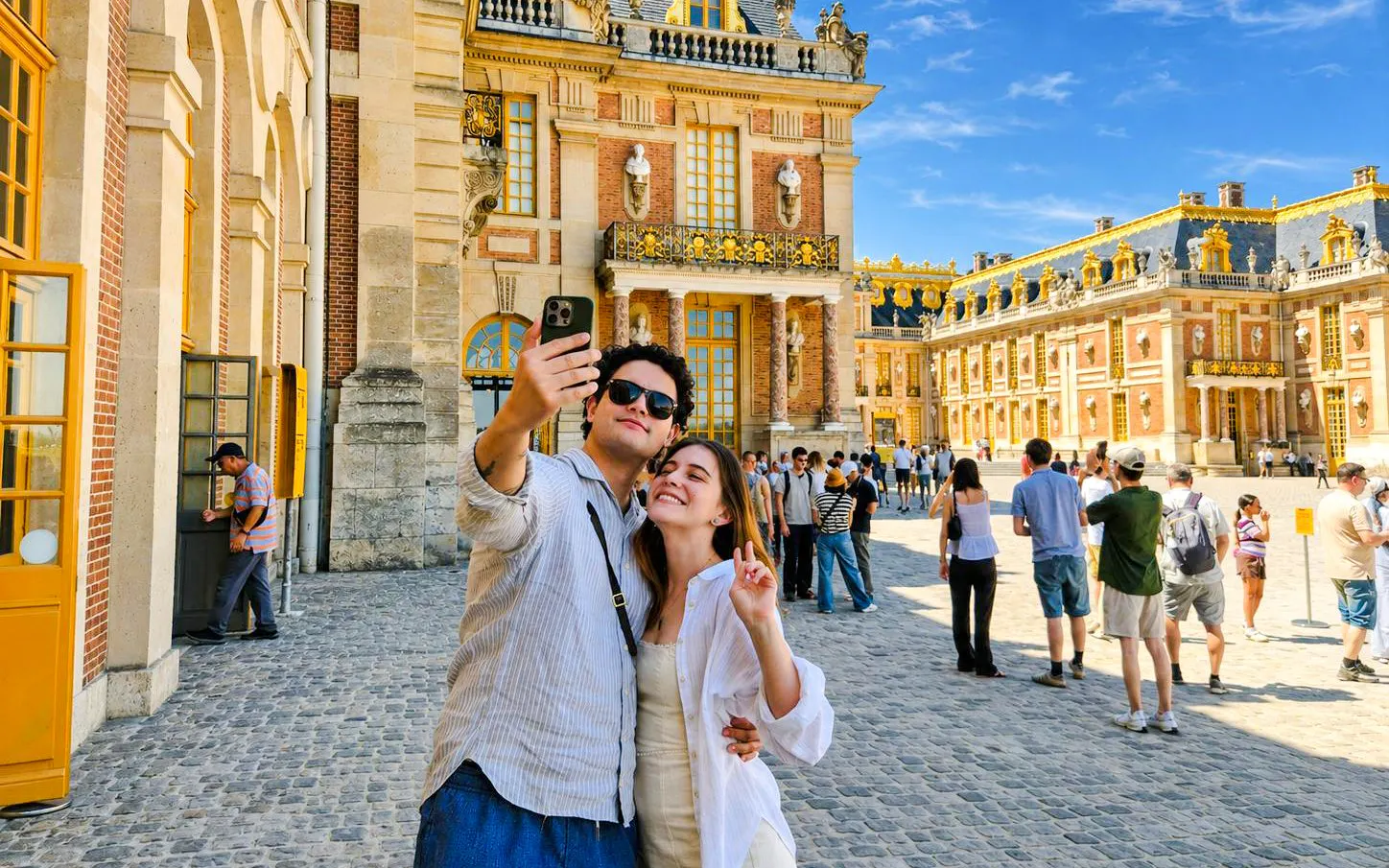 Couple taking selfie at Versailles Palace courtyard during private guided tour.