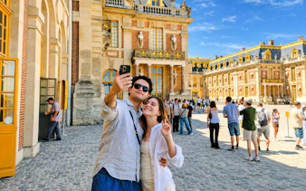 Couple taking selfie at Versailles Palace courtyard during private guided tour.