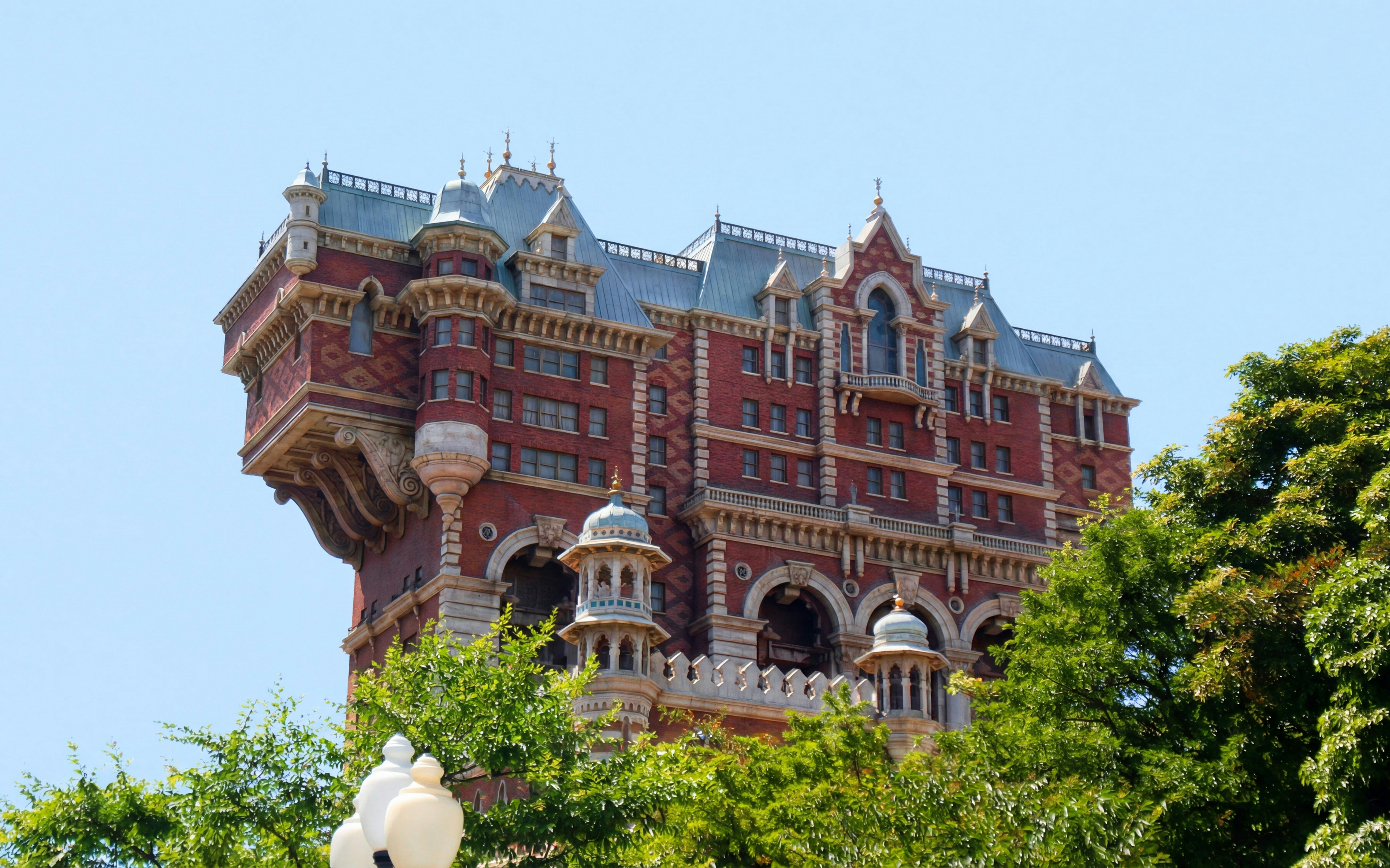 Tower of Terror building at Disney Sea, Tokyo, Japan, surrounded by trees.