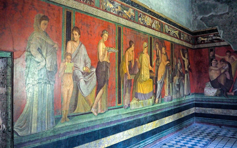 Mural depicting figures in a room inside a house in Pompeii, Naples.