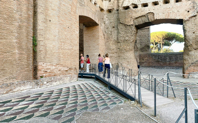 Visitors exploring the ancient ruins of the Baths of Caracalla in Rome.