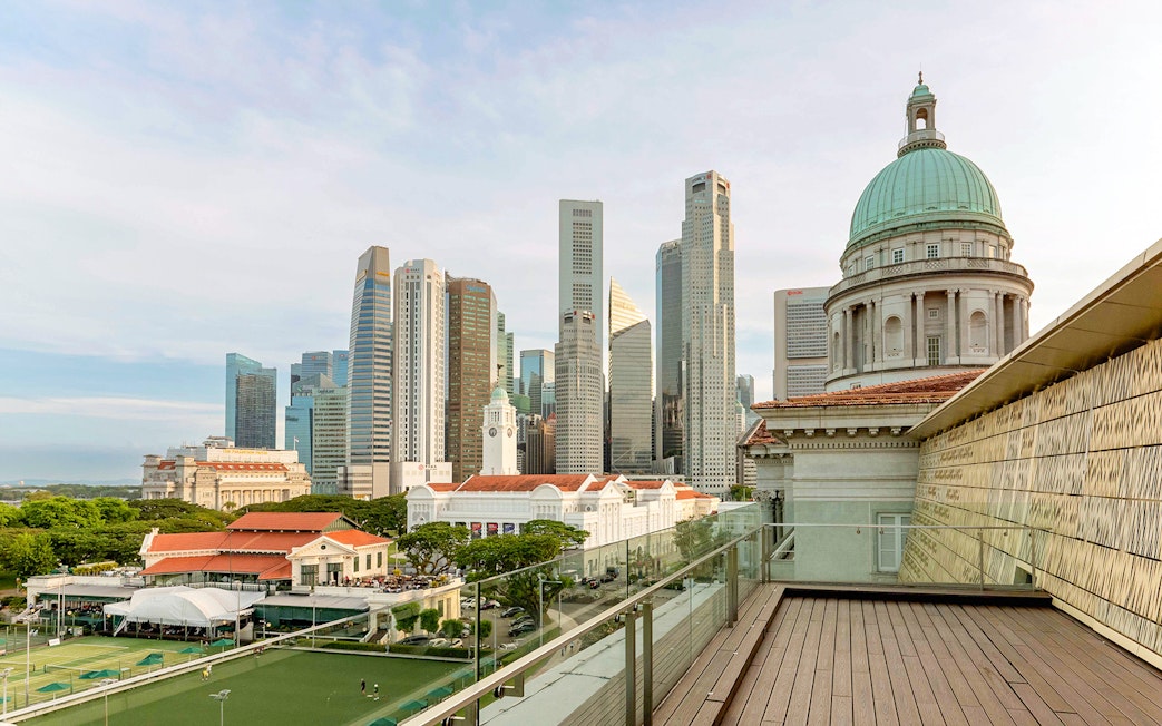 Rooftop view from National Gallery Singapore with city skyline and historic dome.