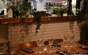 Private dining setup in Icelandic restaurant with glassware and plants.