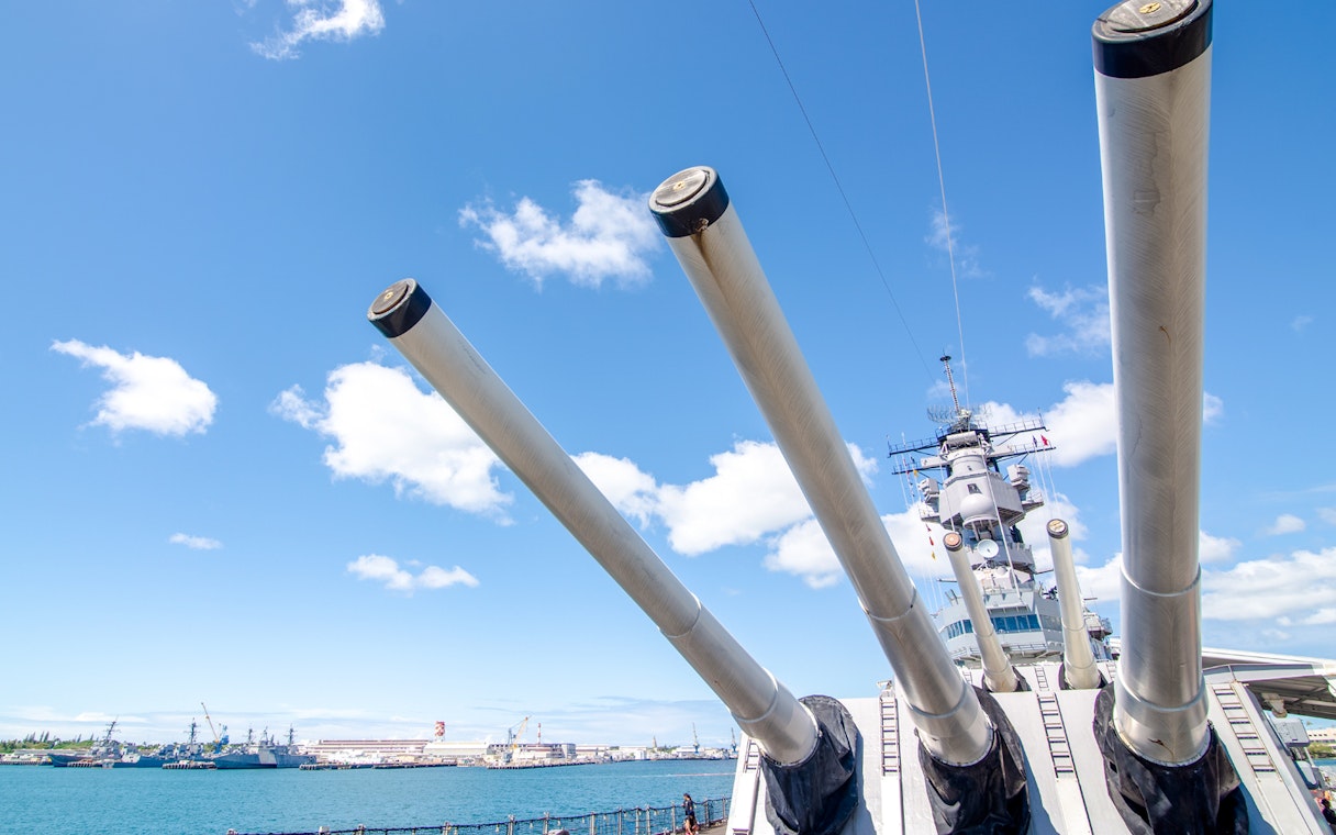 Battleship Missouri Memorial's large naval guns against a clear sky in Pearl Harbor.