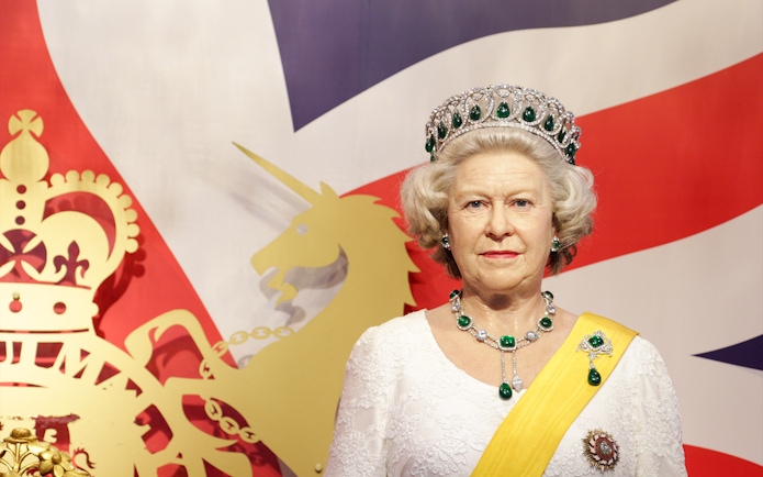 Wax figure of a royal figure at Madame Tussauds Bangkok with a British flag backdrop.