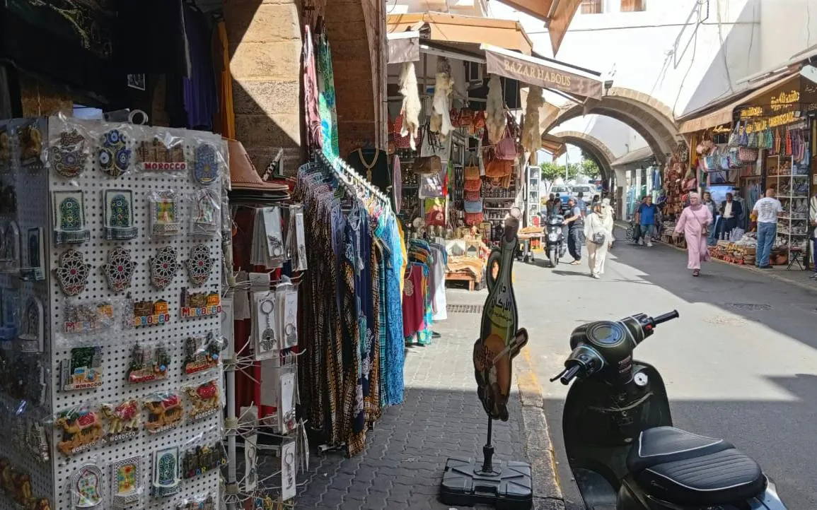 Bazaars in Marrakech with colorful clothing and souvenirs, part of Casablanca day trip.