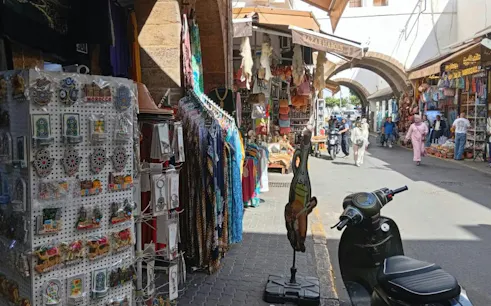 Bazaars in Marrakech with colorful clothing and souvenirs, part of Casablanca day trip.