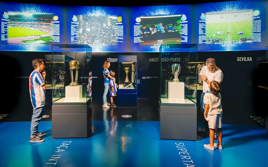 Visitors at FC Porto stadium museum viewing trophies in the trophy room.