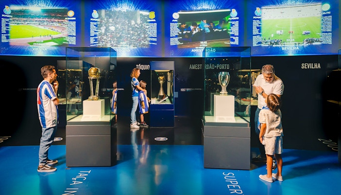 Visitors examining FC Porto stadium museum trophies in trophy room, Porto, Portugal.