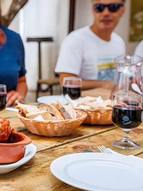 Tourist sampling Chorizo during Lisbon Food Walk in Baixa.