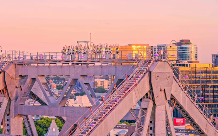 Climbers on Story Bridge during sunset in Brisbane, Australia.