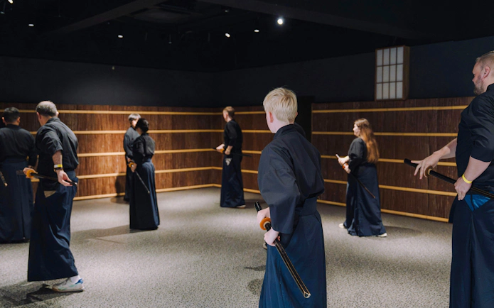 Practitioners learning samurai sword techniques in Shinjuku dojo.
