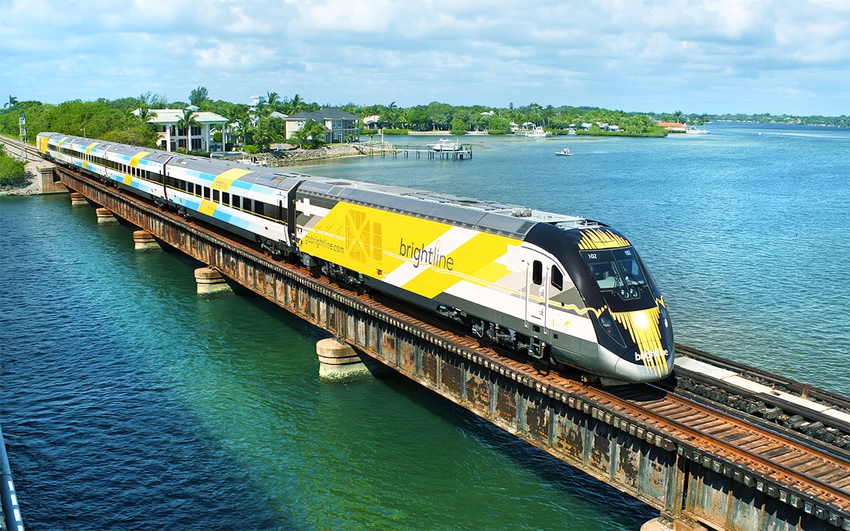 Train crossing a bridge over water on a Miami trip with open top bus and islands boat cruise.