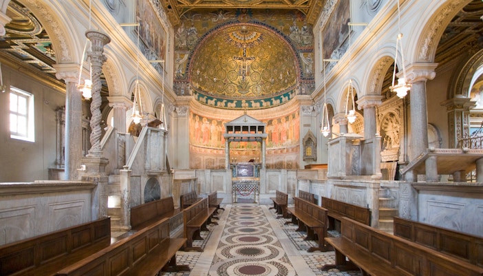 Interior of San Clemente Basilica in Rome with ornate frescoes and marble columns.