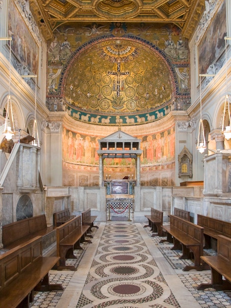 Interior of San Clemente Basilica in Rome with ornate frescoes and marble columns.