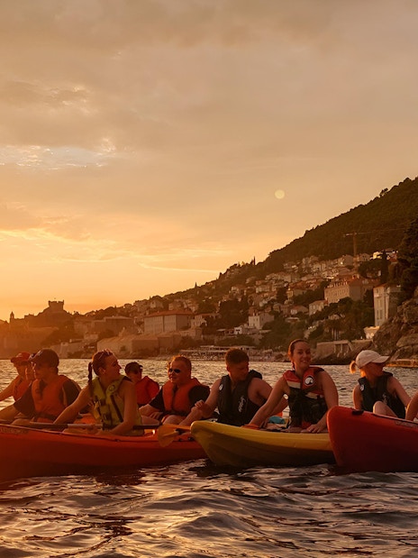 Kayakers at sunset near Old Town Walls, Betina Cave Beach, and Lokrum Island.