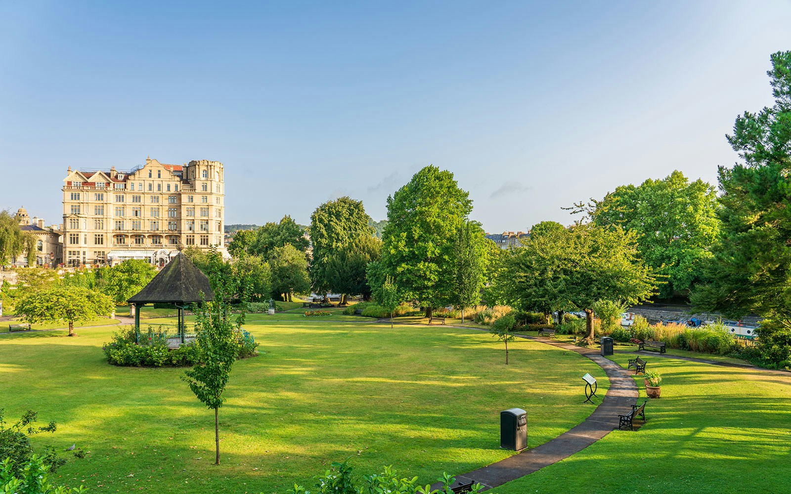 Parade Gardens in Bath with a gazebo, lush greenery, and a historic building in the background.
