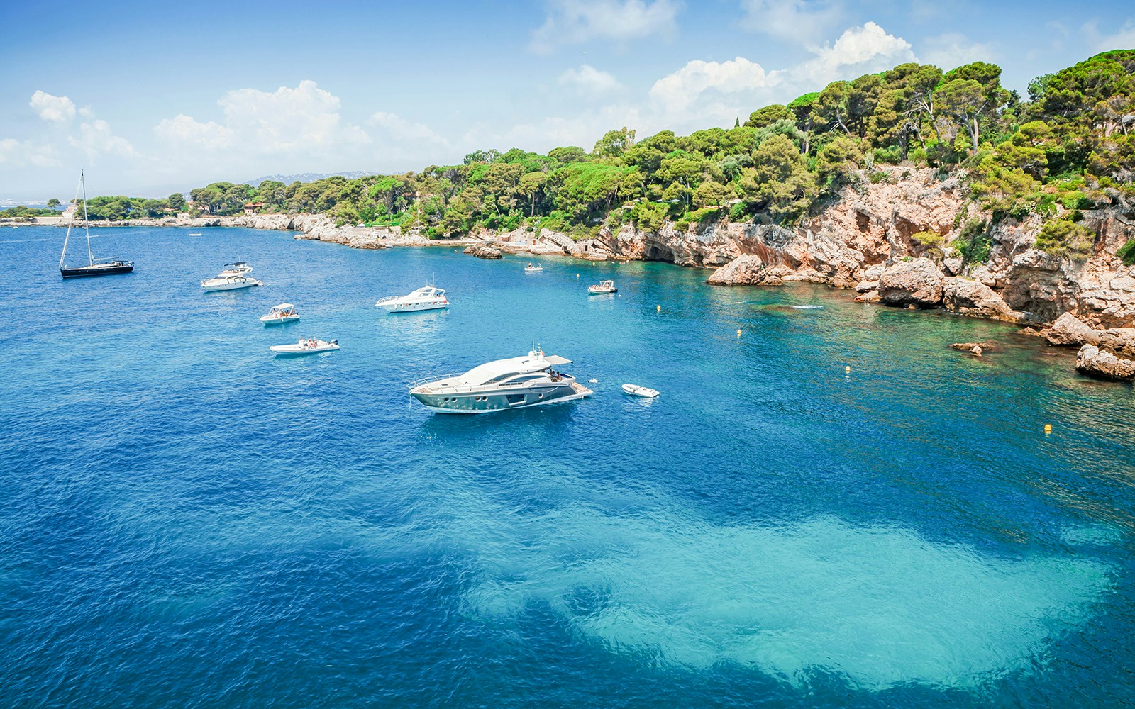 Boats in turquoise waters near lush vegetation, Cap d'Antibes, Nice.