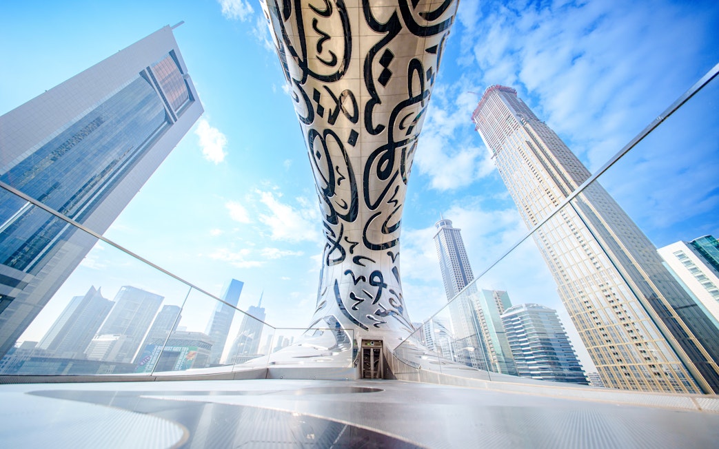 Futuristic architecture of the Museum of the Future in Dubai with surrounding skyscrapers.