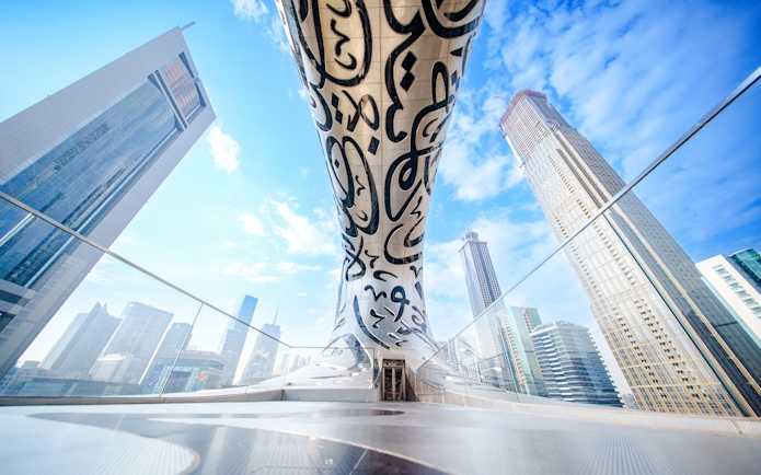 Futuristic architecture of the Museum of the Future in Dubai with surrounding skyscrapers.