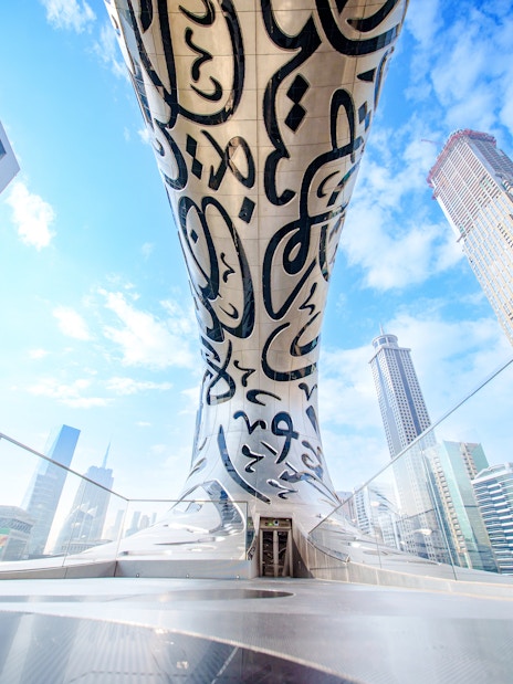 Futuristic architecture of the Museum of the Future in Dubai with surrounding skyscrapers.