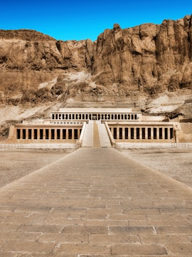 Hatshepsut Temple in Valley of the Kings, Egypt, with rocky cliffs in the background.