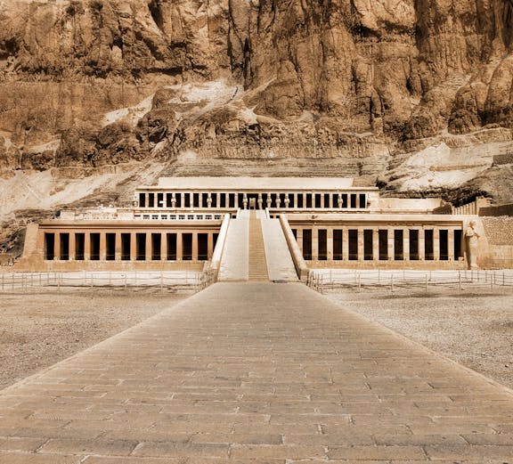 Hatshepsut Temple in Valley of the Kings, Egypt, with rocky cliffs in the background.