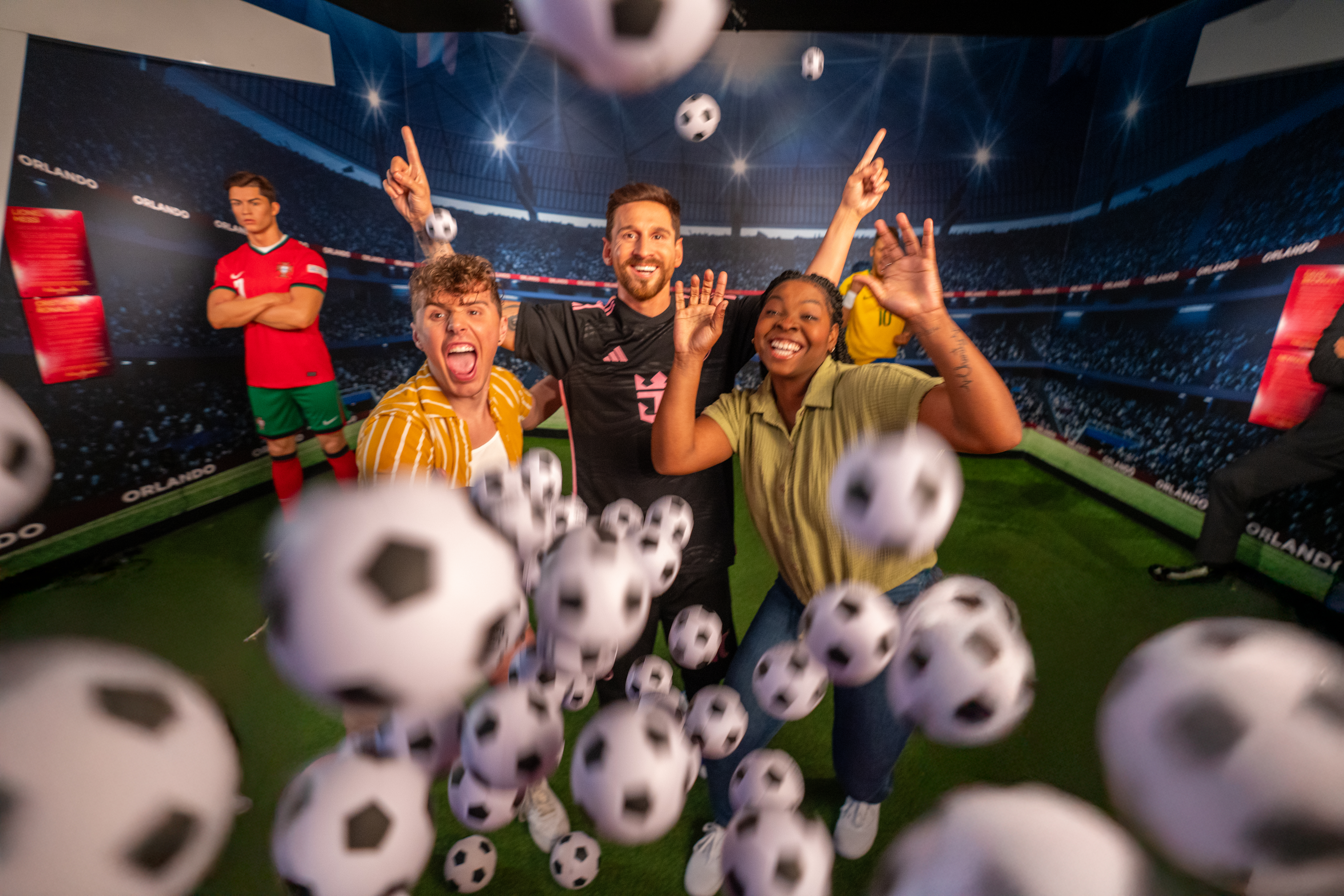Visitors interacting with soccer-themed exhibit at Madame Tussauds Orlando.