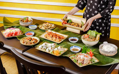All-you-can-eat Vietnamese dishes at HOME Hoi An Restaurant, featuring seafood and fresh vegetables.