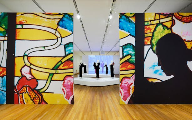 Exhibit of stained glass art and mannequins at M+ Museum.