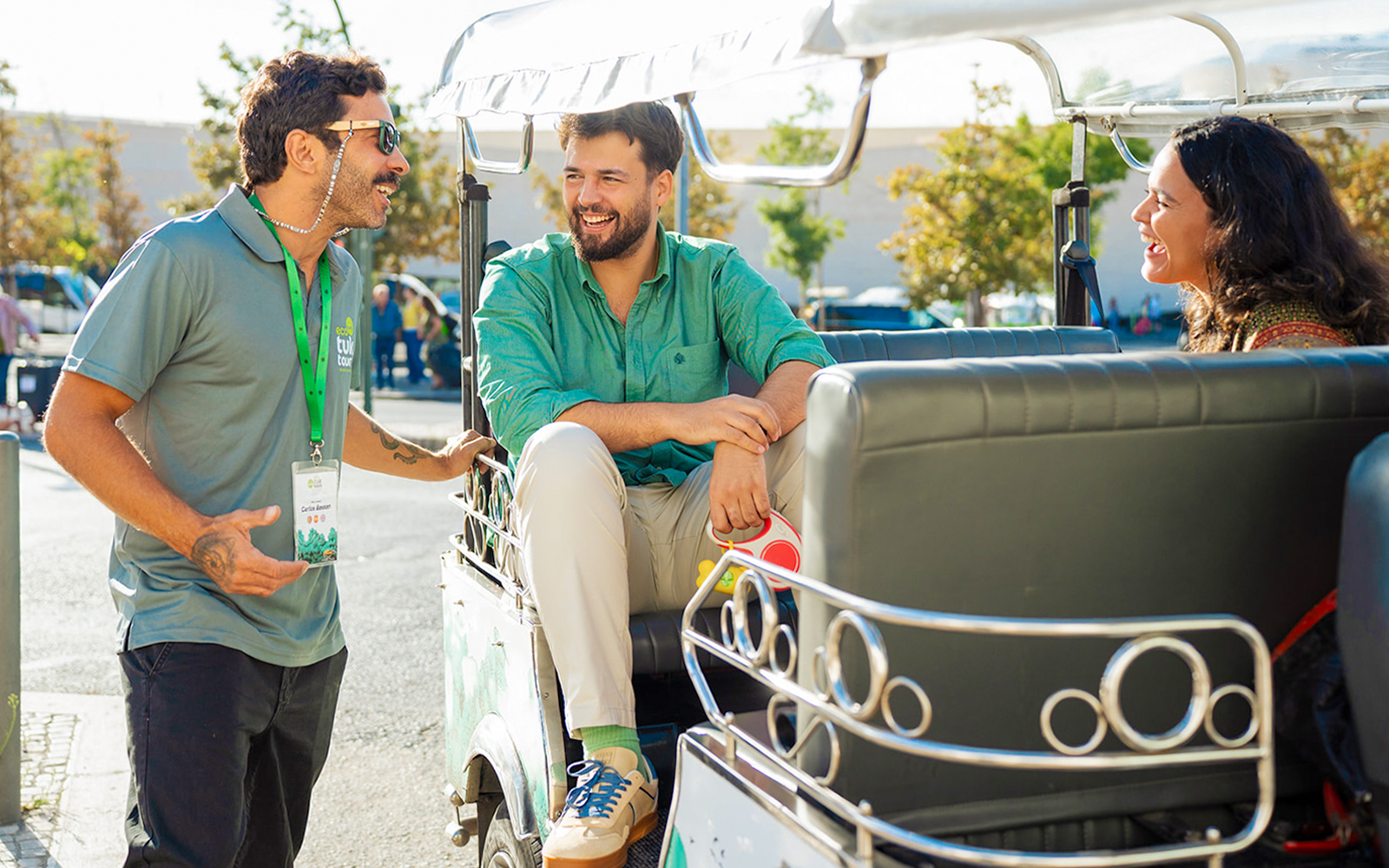 Tourist guide talking with tourists on a tuk tuk in Lisbon.