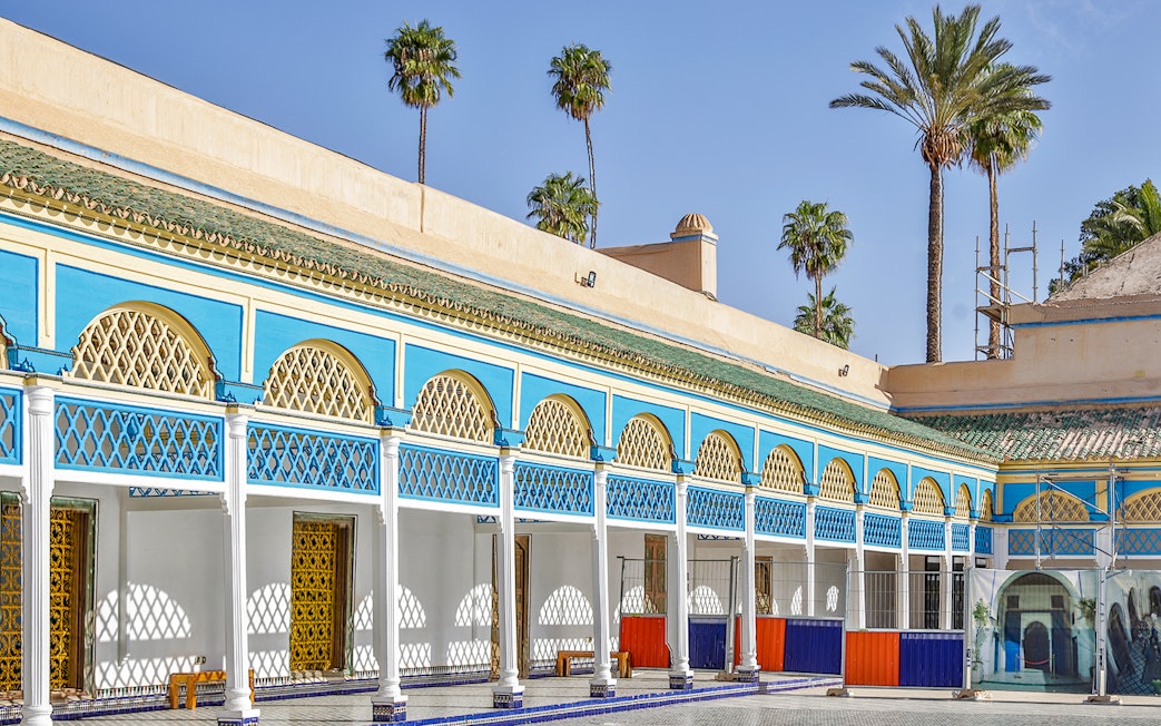 Bahia Palace courtyard with blue and yellow arches in Marrakech, Morocco.