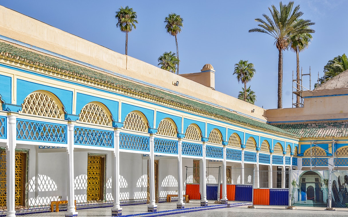 Bahia Palace courtyard with blue and yellow arches in Marrakech, Morocco.