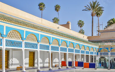 Bahia Palace courtyard with blue and yellow arches in Marrakech, Morocco.