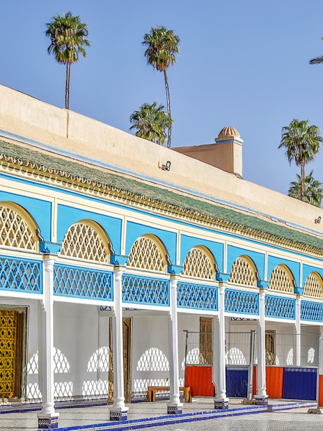 Bahia Palace courtyard with blue and yellow arches in Marrakech, Morocco.