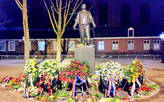 Statue with floral wreaths at Jewish history site in Amsterdam.