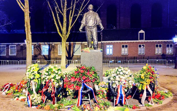 Statue with floral wreaths at Jewish history site in Amsterdam.