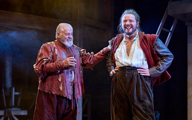 Actors in period costumes performing a scene from "Hamnet" on stage.