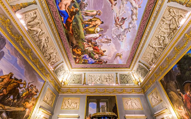 Ceiling frescoes and ornate decorations inside Pitti Palace, Florence, Italy.
