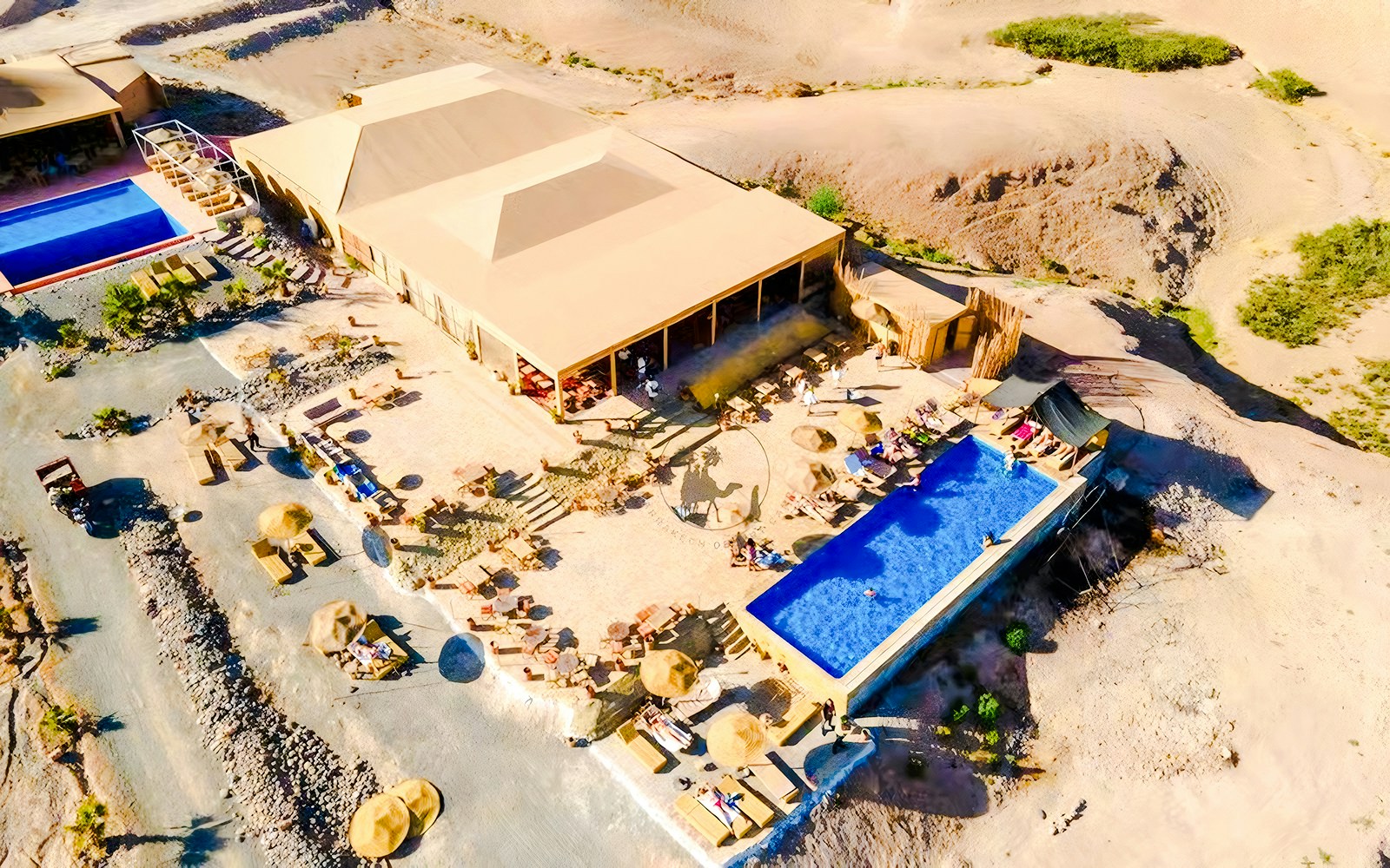 Aerial view of Agafay desert camp with pool and seating area near Marrakech.