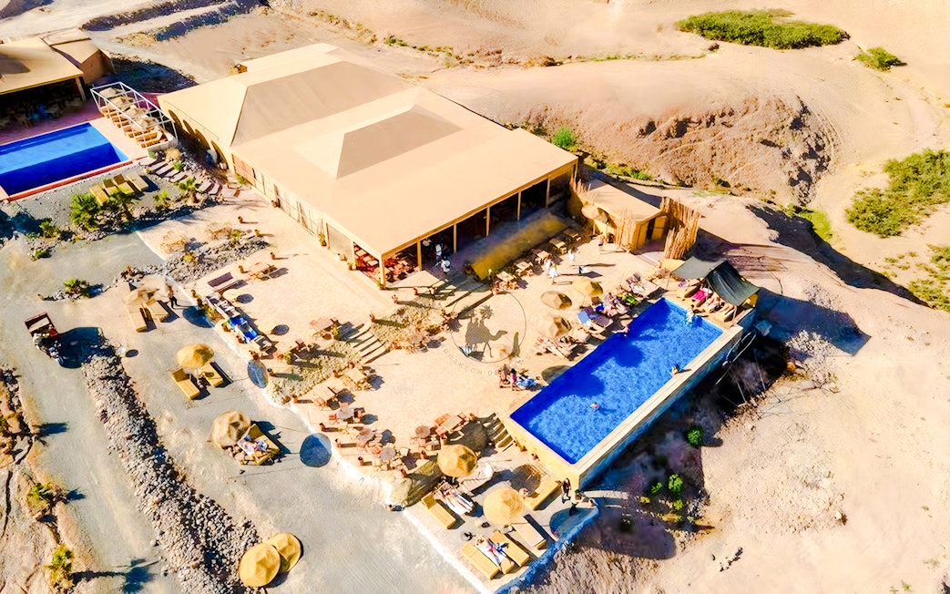Aerial view of Agafay desert camp with pool and seating area near Marrakech.