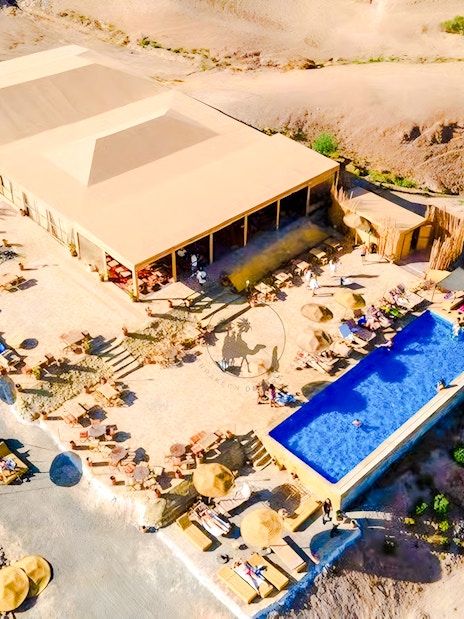 Aerial view of Agafay desert camp with pool and seating area near Marrakech.