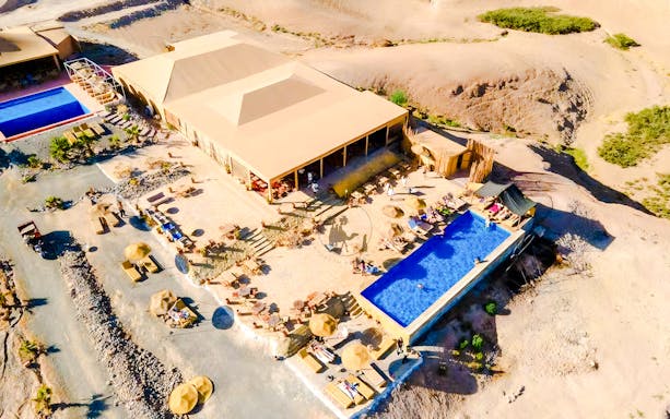 Aerial view of Agafay desert camp with pool and seating area near Marrakech.