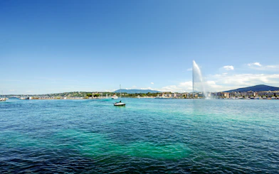 Sailboat on Lake Geneva with Jet d'Eau fountain in the background.