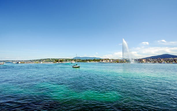 Sailboat on Lake Geneva with Jet d'Eau fountain in the background.